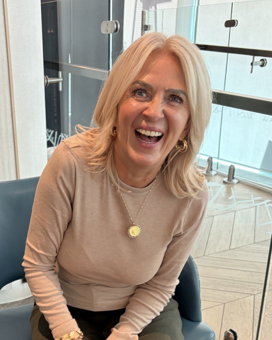 Laurie Traquair laughing, sitting forward in an armchair